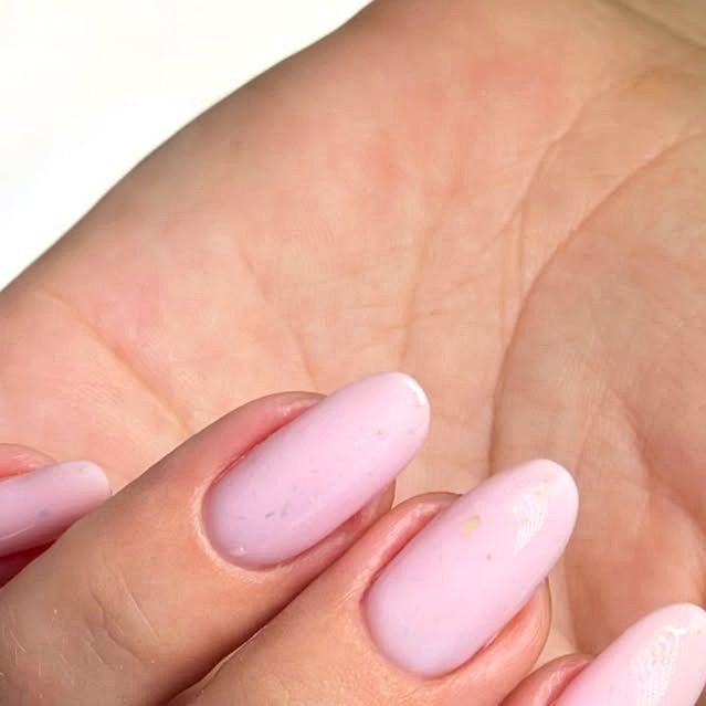 Soft pink almond manicure held in the palm